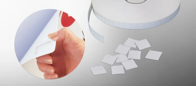 A roll of pre-cut foam squares and loose squares, with a hand peeling one off